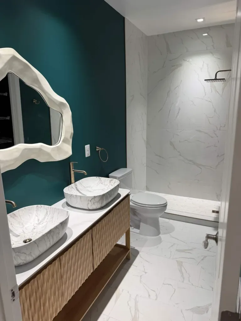 Teal accent wall with double vessel sinks & fluted vanity